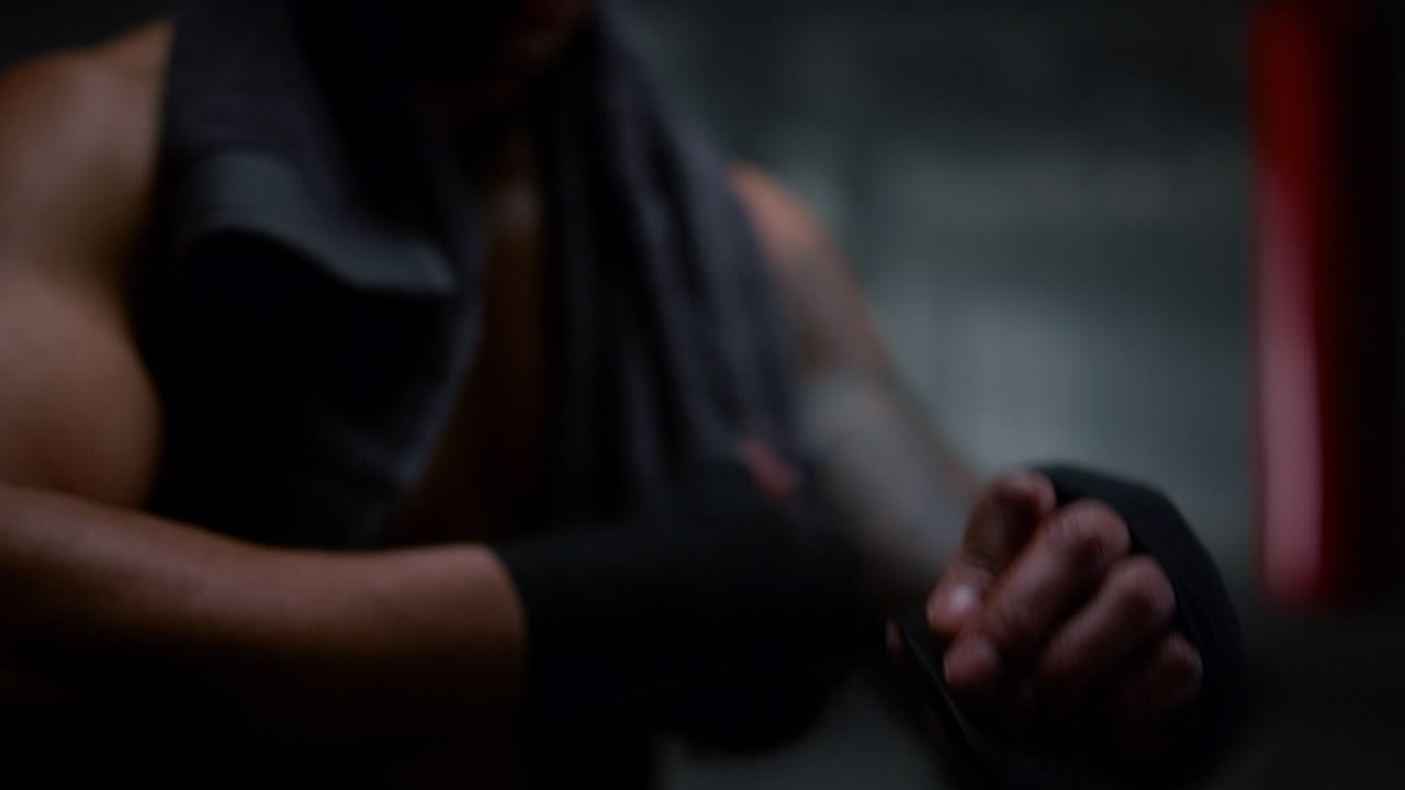 ⁇ 복싱 싸움을 준비하는 남자.  ⁇ 복싱 테이프로 손을 감싸는 남자