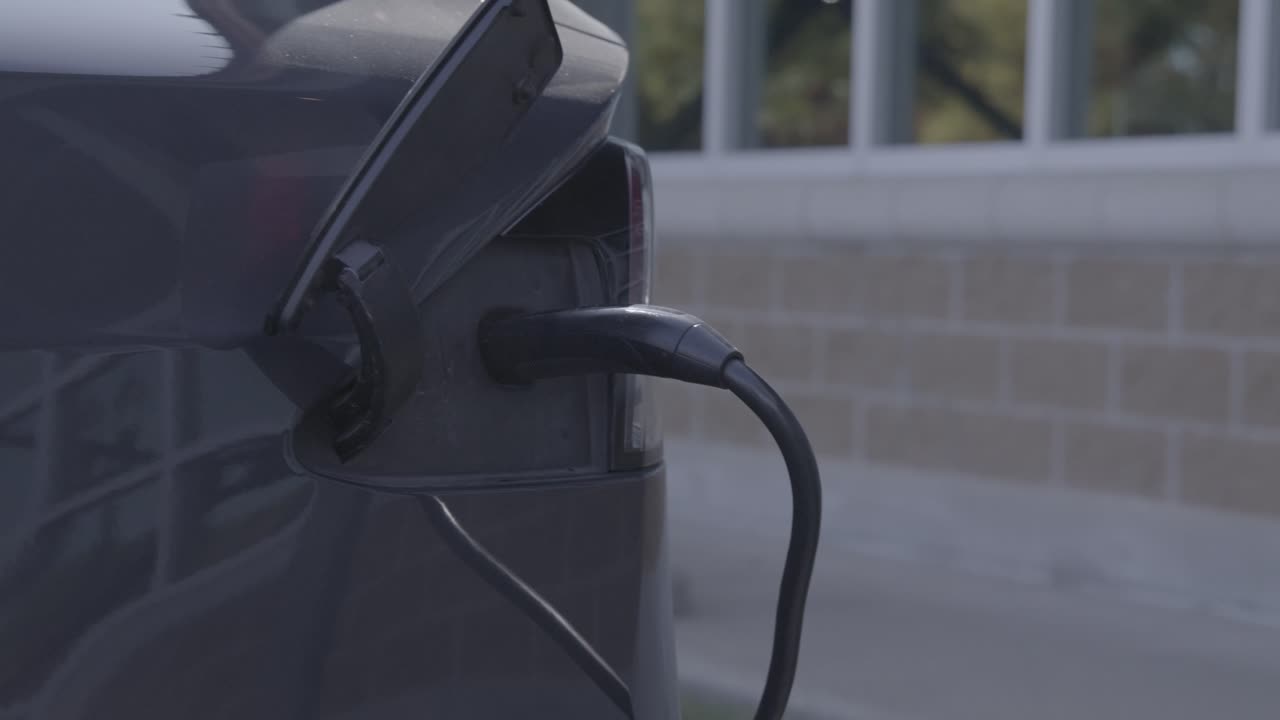 Tesla Cybertruck being charged with electricity and video moving right to left.