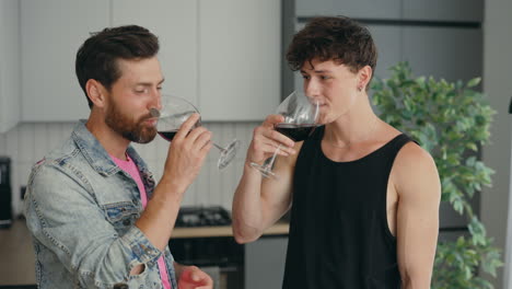 two men enjoying wine in a kitchen