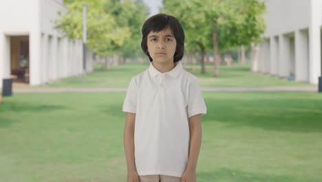 angry indian boy looking at the camera in park