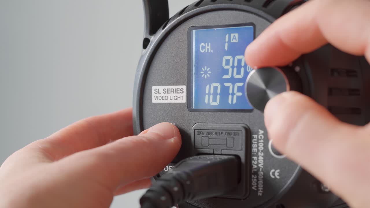 led 비디오 조명을 켜고 밝기를 조정하는 남자