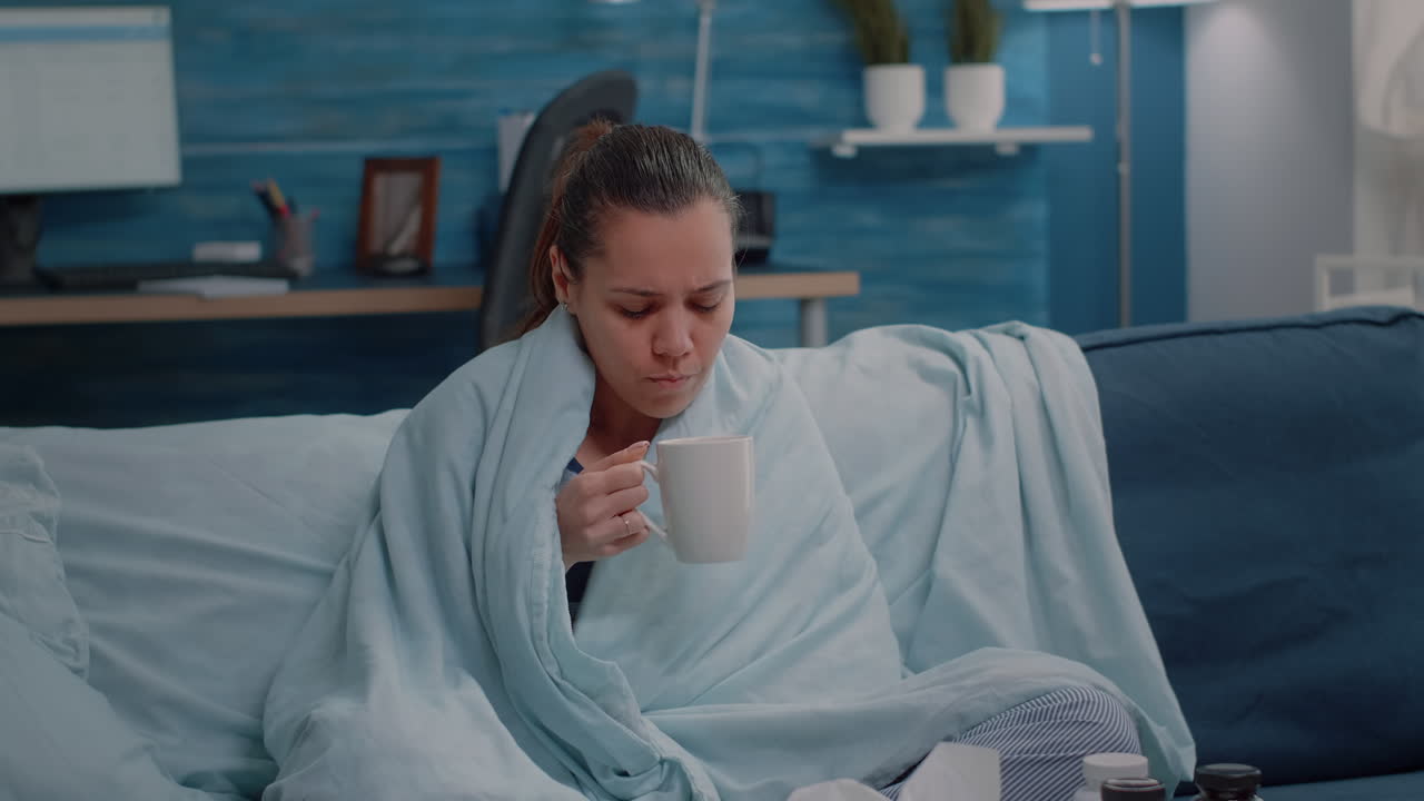 Sick woman with cold and flu blowing runny nose