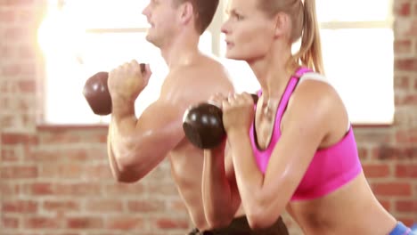 Fit-man-and-woman-using-kettlebells