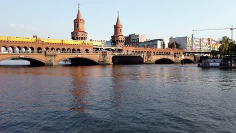 famous oberbaumbruecke in berlin during summer day with boats on river