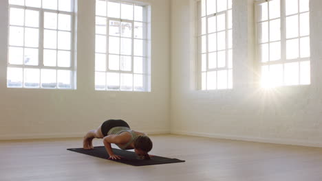 healthy yoga woman practicing cobra pose enjoying fitness lifestyle exercising in workout studio stretching training on exercise mat at sunrise