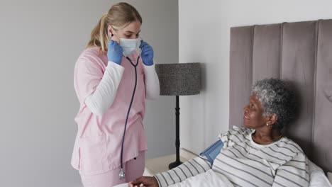 Caucasian-female-nurse-in-face-mask,-senior-african-american-woman-with-oxygen-mask,-slow-motion