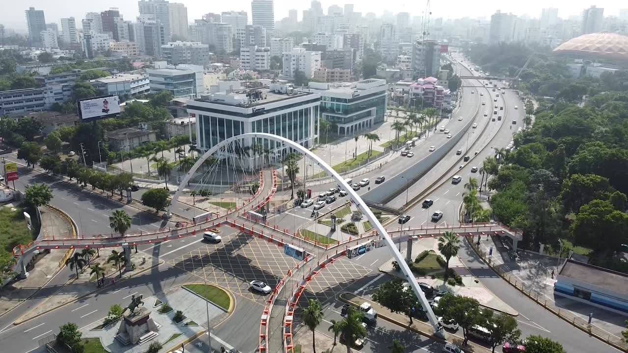 toma estática de drones del puente peatonal con vista de edificios en el fondo, clima soleado en santo domingo