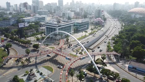 static drone shot of the pedestrian bridge with view of buildings in the background, sunny weather in santo domingo