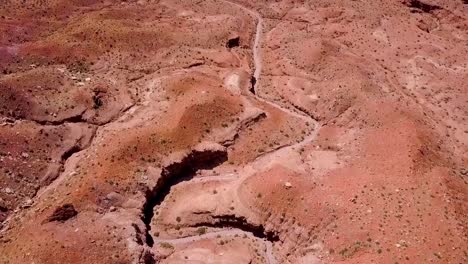looking down, flying over alien, martian looking desert landscape, wash, creek