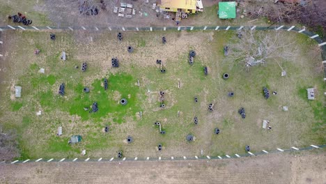 Drone-shot-of-paintball-players-playing-a-game-of-paintball-on-the-field