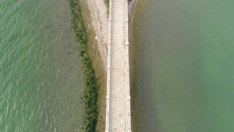 aerial-drone-footage-on-bridge-road-arriving-at-small-greek-exotic-island,-Koukoumitsa-Vonitsa-Greece