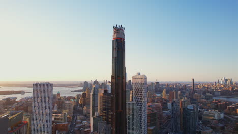 orbit shot of brooklyn tower under construction with waterfront view in background, nyc