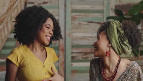 disco time. two stylish african american ladies in traditional clothes dancing, smiling to each other and to camera