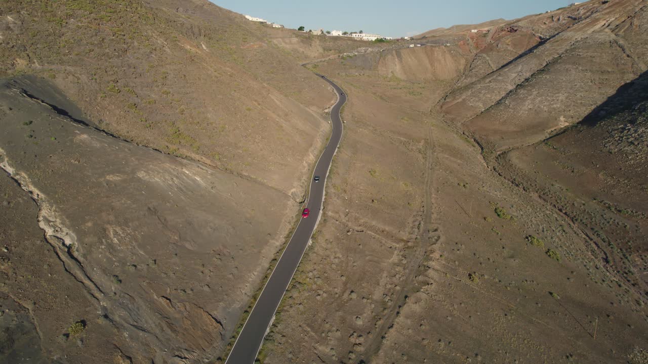 바위 산 들 이 둘러싸고 있는 굴곡 된 도로 를 잃고 그 도로 를 따라 이동 하는 여러 차량 이 있다