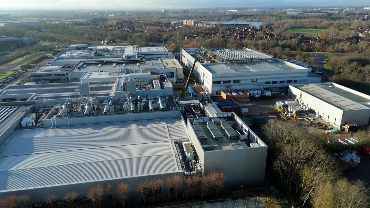 Aerial view of industrial factories and high-capacity fulfillment centers with integrated road transport networks.