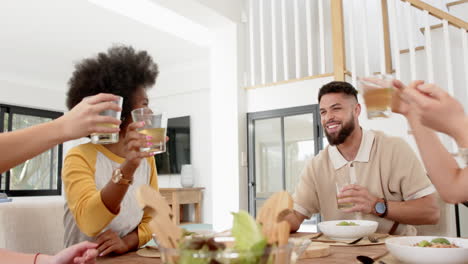 friends toasting with drinks around dining table, enjoying meal together