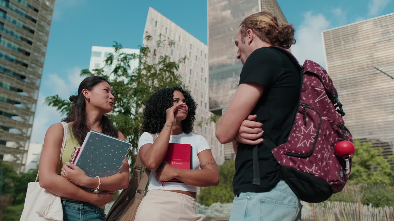Side view of millenial friends, Asian and african-american girls talking to