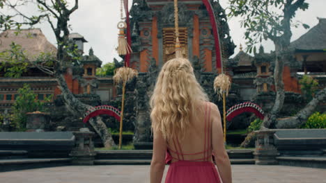 Glückliche-Frau-Tanzt-Im-Saraswati-Tempel-Und-Feiert-Reisen-Und-Genießt-Die-Kultur-Balis,-Indonesiens-4k