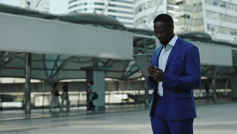professional black man using tablet in city