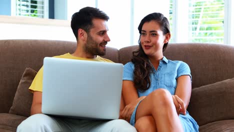 pareja usando una computadora portátil en la sala de estar