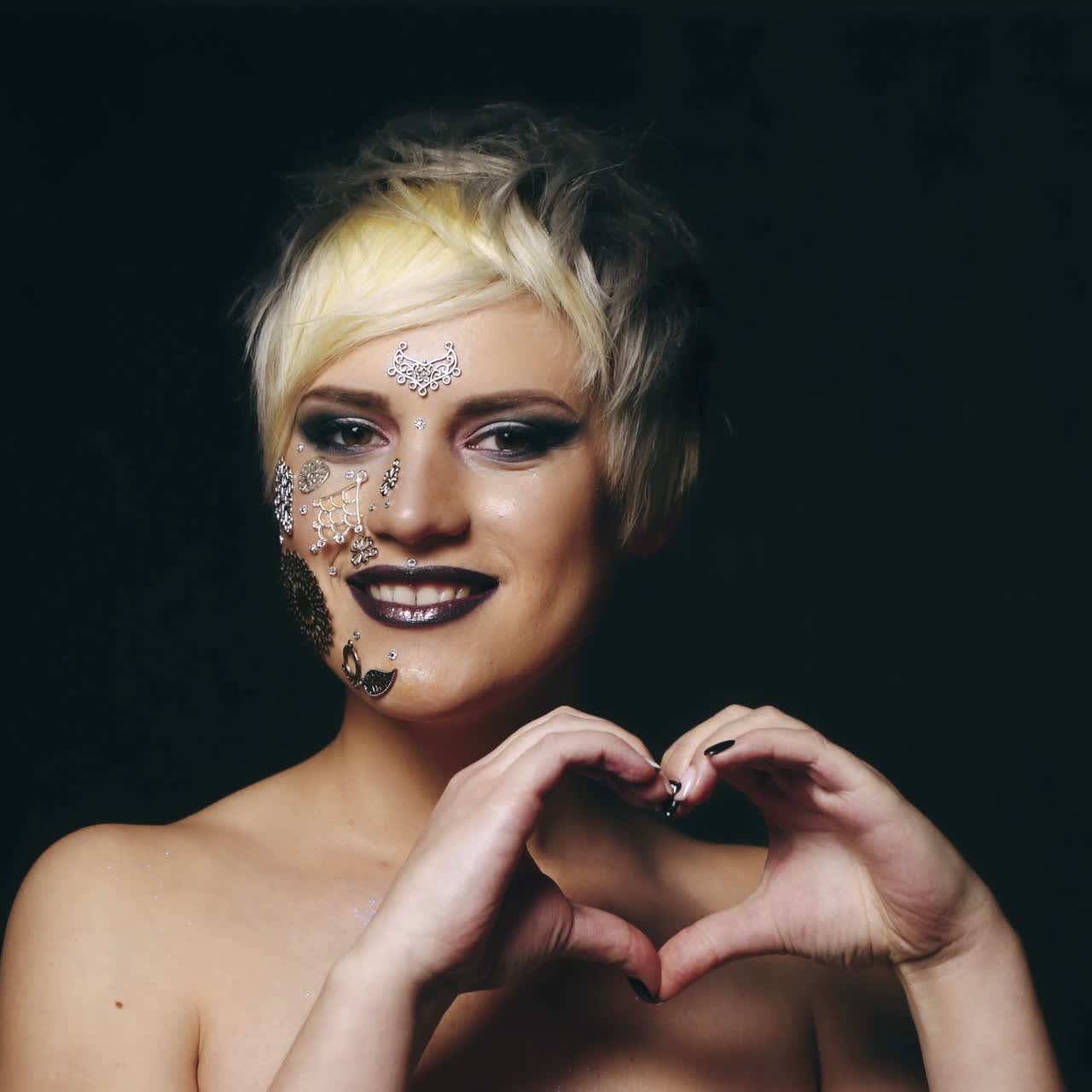 la mujer sostiene sus dedos en el corazón