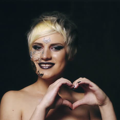 la mujer sostiene sus dedos en el corazón
