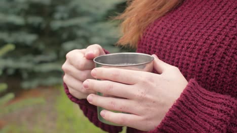 la mano de la mujer sosteniendo una taza de té