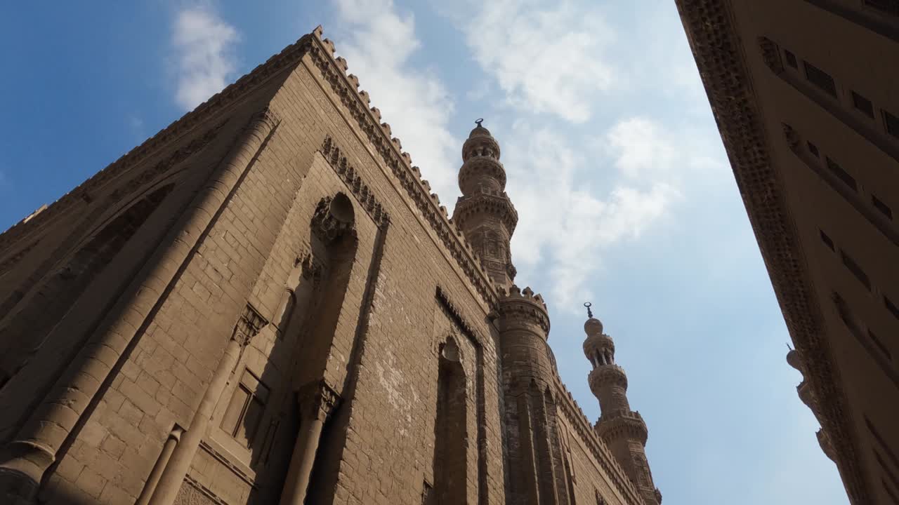 vista externa de la mezquita madrasa del sultán hassan y sus torres elevadas cairo, egipto ángulo bajo