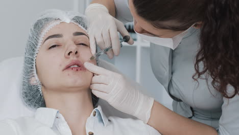 woman receiving lip filler injections at a beauty clinic