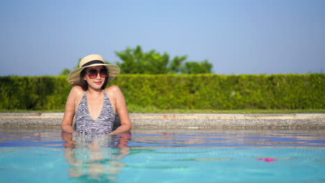 Mujer-De-Moda-Sentada-En-La-Piscina