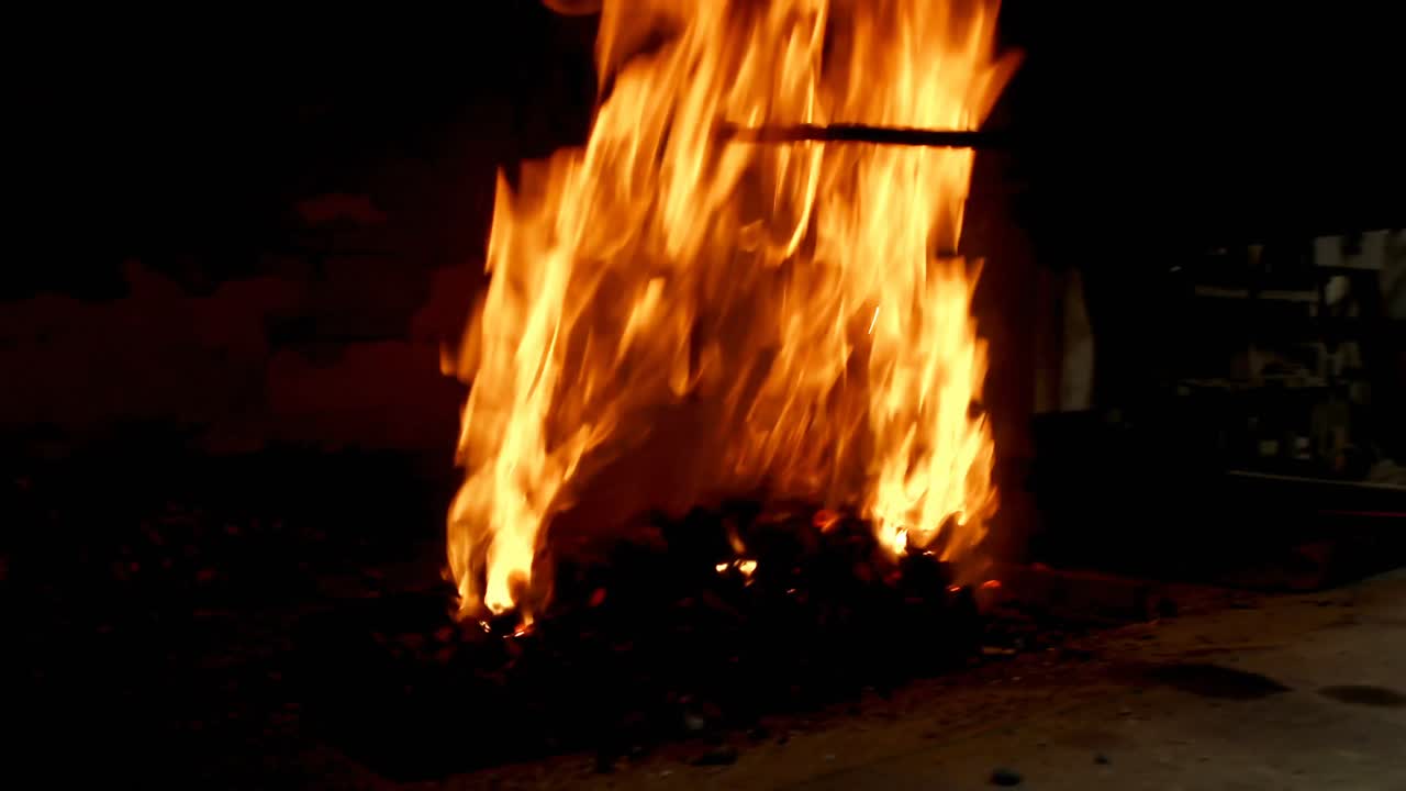 herrero calentando una varilla de metal en el fuego 4k