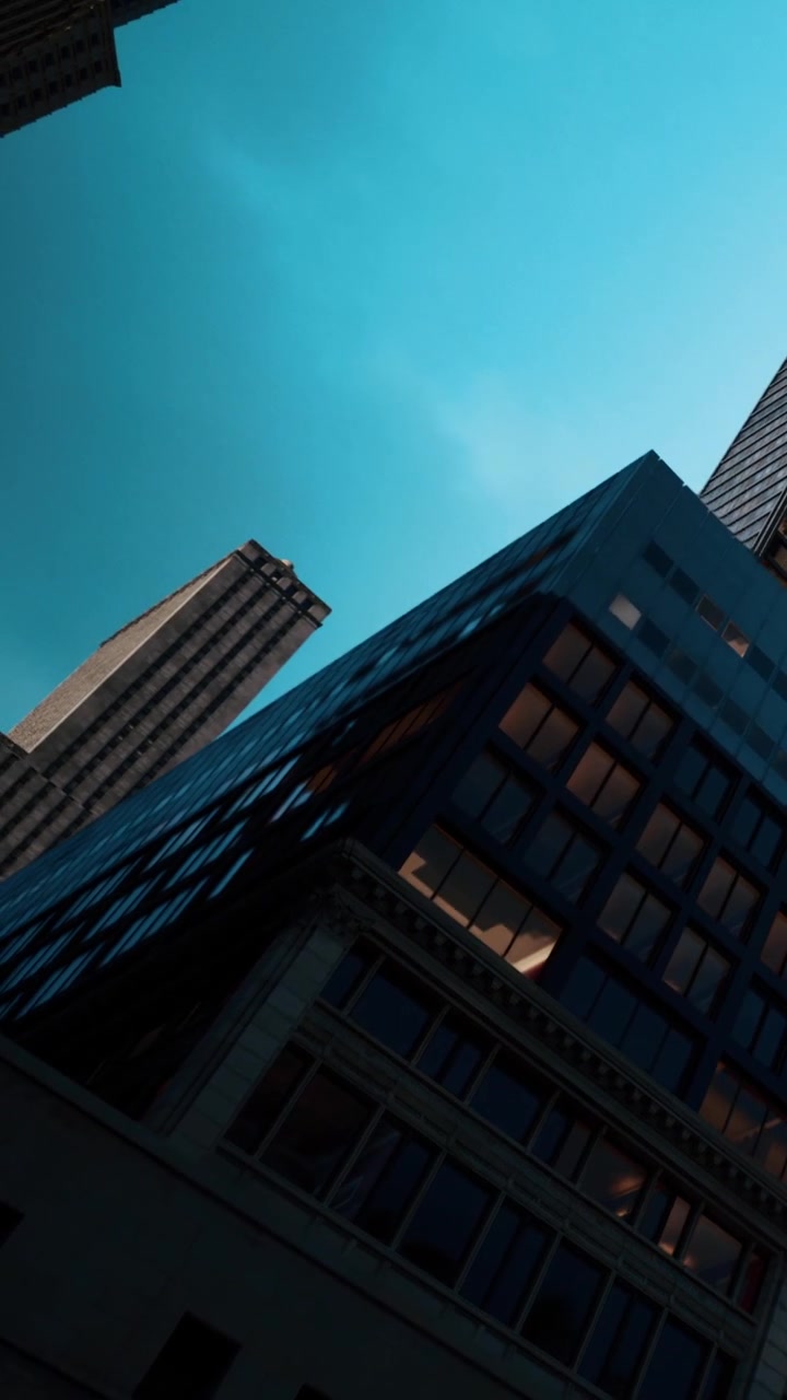 Edificios altos bajo un cielo azul en un entorno urbano durante el día.