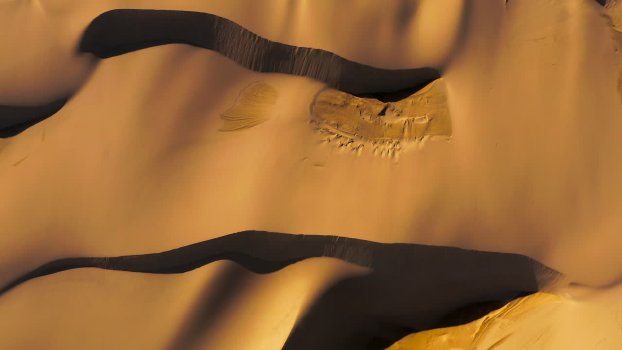 vista de pájaro avanzando toma de drones de dunas de arena con árboles verdes en el fondo