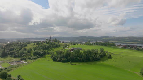 Beautiful-Scenery-Of-Farm-Landscape-With-Distant-Church-On-A-Hilltop-On-A-Sunny-Day