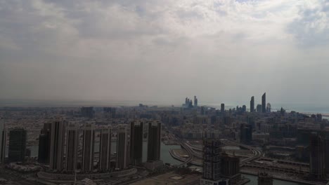 aerial time lapse view of abu dhabi city skyline and skyscrapers against the cloudy sky - middle east, united arab emirates