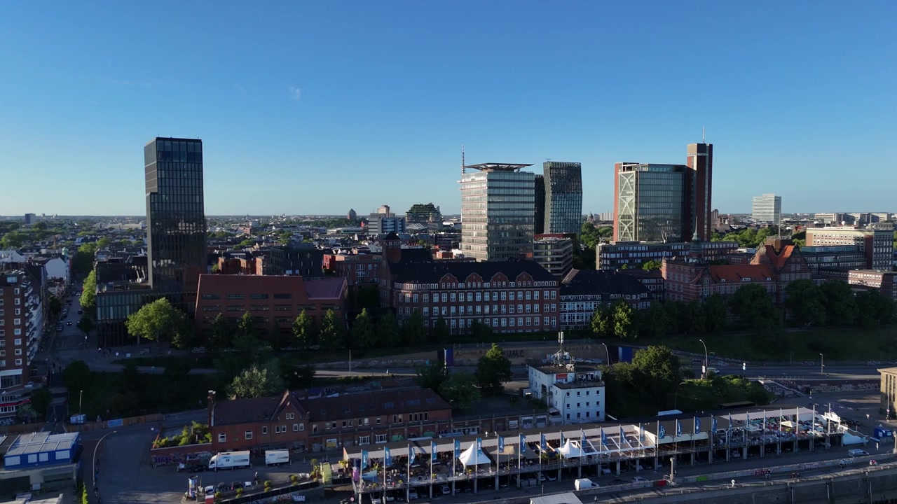 Droneudsigt ud over Landungsbrücken mod Empire Riverside Hotel, nærliggende havnefrontstårne og Hamburg Fernsehturm i aftenlys
