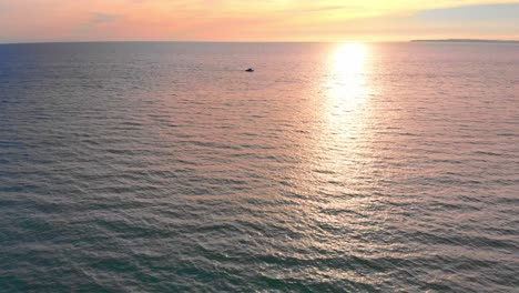 drone vuela sobre el barco en el océano en la colorida puesta de sol
