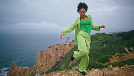girl dancing dramatic nature in front dark ocean. woman performing contemporary.