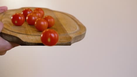 tomates rodando de una tabla de cortar de madera.