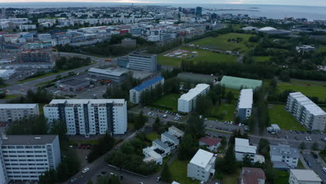Apartment-buildings-in-housing-estate-in-town.-Tilt-up-reveal-of-city-and-sea-coast.-Overcast-day.-Reykjavik,-Iceland