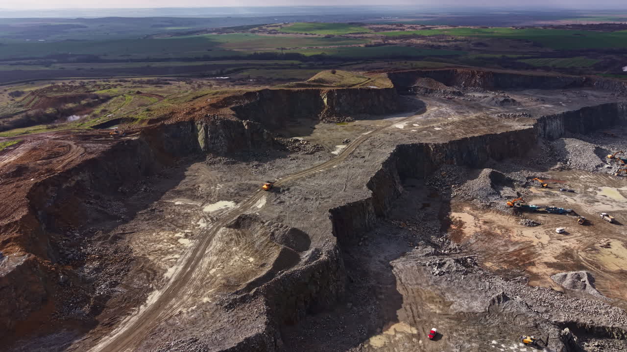 Granite quarry site showing ongoing extraction work and machinery with wide views of the surrounding landscape during daylight hours