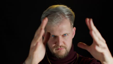 man with white hair and beard looking at the camera