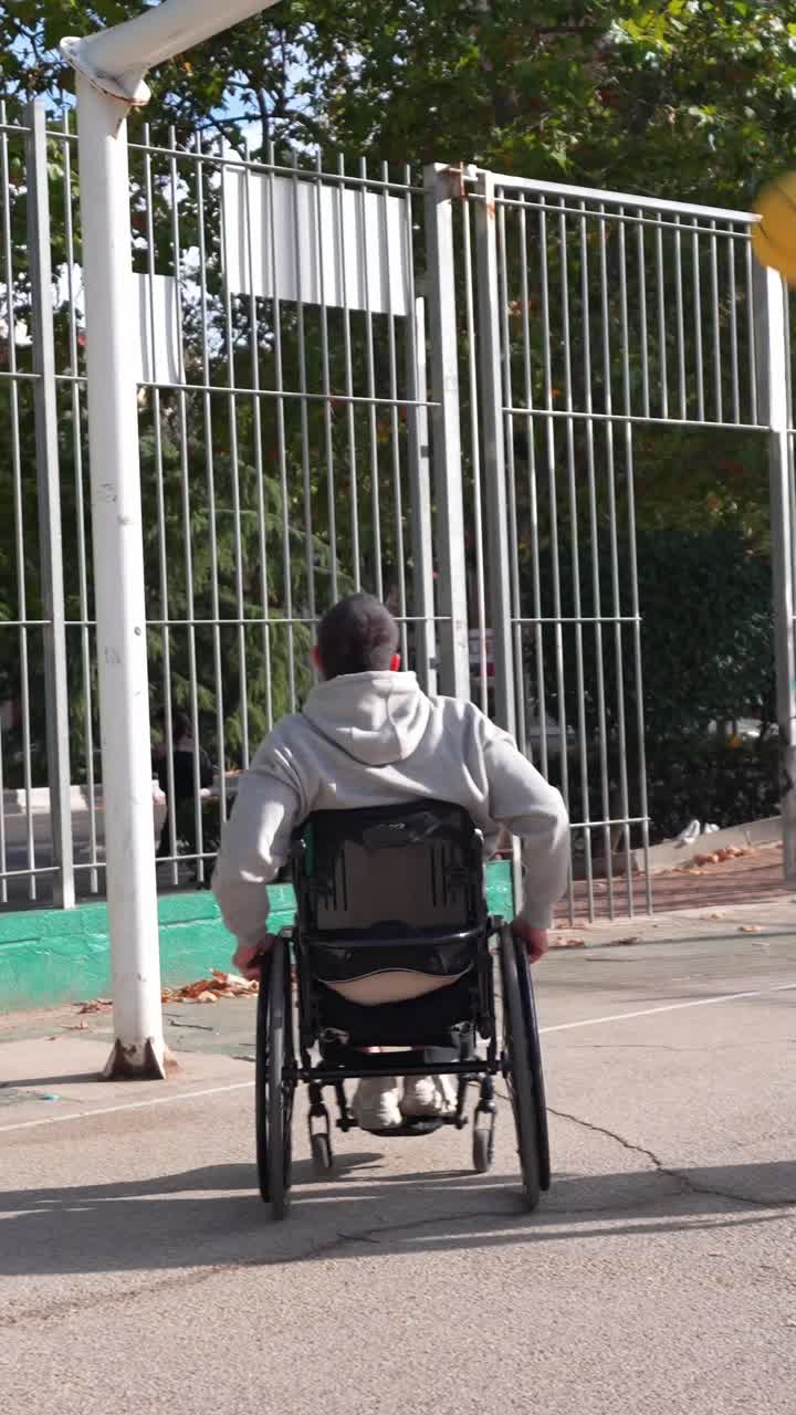 Joven en silla de ruedas jugando baloncesto con un amigo en una cancha al aire libre