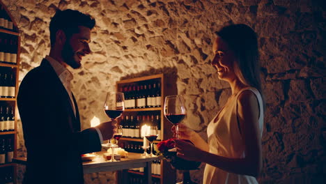 romantic couple enjoying wine in a wine cellar