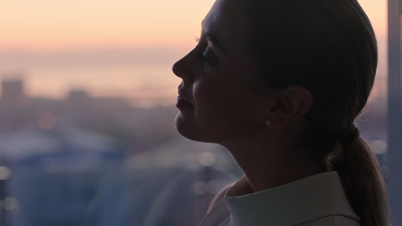hermosa mujer de negocios mirando por la ventana contemplando un estilo de vida exitoso planeando adelante disfrutando de la vista de la ciudad desde el ático al atardecer