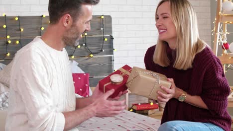 Loving-couple-exchanging-christmas-gifts-each-other