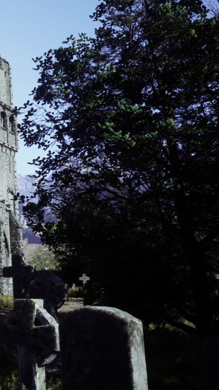 Vecchio campanile di chiesa vicino a un cimitero con alberi sullo sfondo durante il giorno