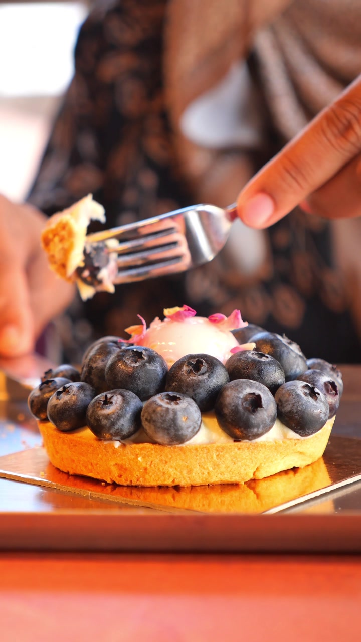 Close-up of a Person Cutting and Eating a Delicious Blueberry Tart