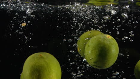 slow motion citrus abstract limes splashing in liquid with bubbles