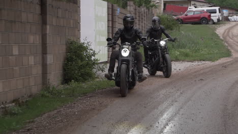 two motorcyclists on a dirt road